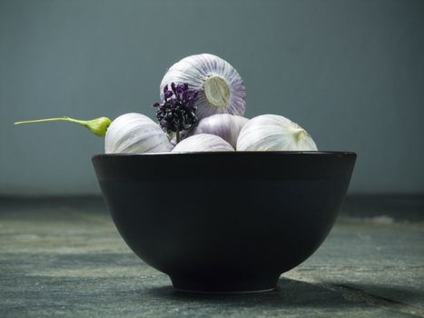 bowl full of fresh garlic on dark background