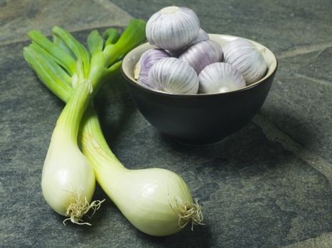 bowl full of fresh garlic on dark background