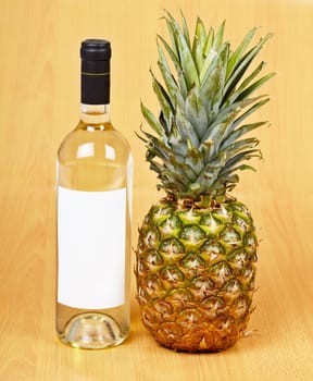 A bottle of white wine and a large ripe pineapple