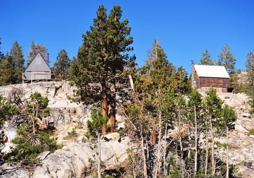 Two mountain cabins sit atop a solid bedrock hilltop in the California Sierra Nevada Mountains.