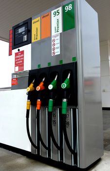 Four gas pump nozzles on a petrol station