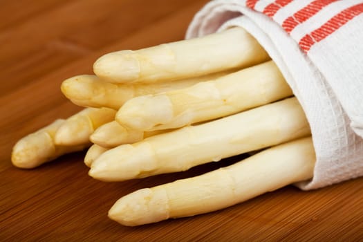 raw white asparagus on a wooden blank