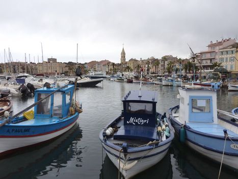 Boats and buildings at Sanary-sur-mer port, south of France, by cloudy weather