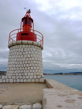 Red lighthouse in Sanary-sur-mer, south of France, by cloudy weather