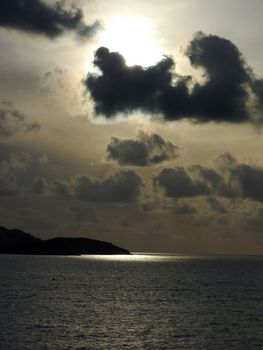 Ray of light through big grey clouds and near an island on the mediterranean sea at Marseilles, France