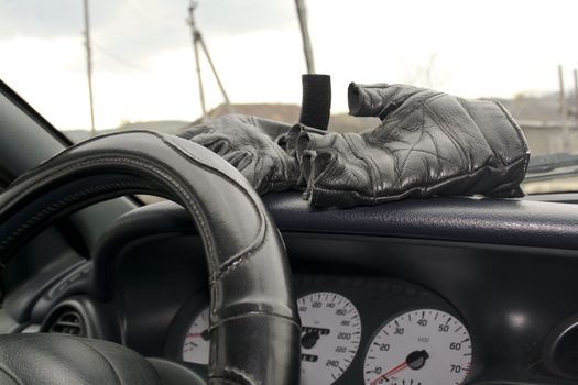 Leather gloves in torpedo cars, steerinf wheel, speedometer