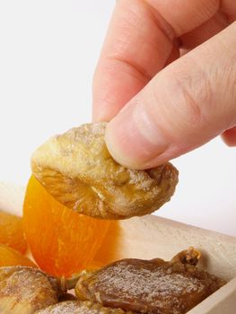 Hand taking a dried fruit