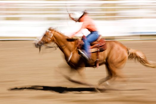 A horse galloping fast with a female rider -  motion blur.