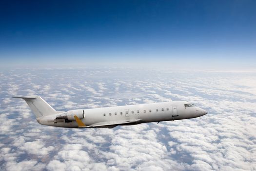 Airplane in flight over high altitude clouds