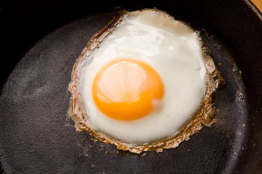 Detail image of a fried egg on a cast iron frying pan