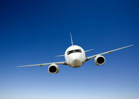 Airplane in flight against a bright blue sky