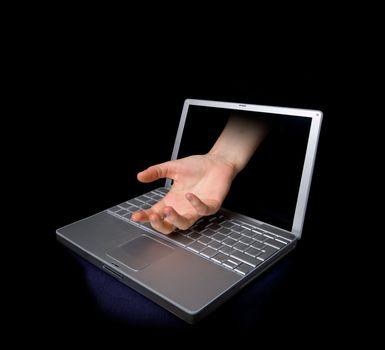 An open hand coming through a computer screen.