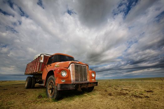 An old farm truck against a dramatic prairie landscape