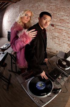 Cool DJ with turntable and blonde lady with pink coat