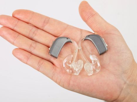 Hand holding hearing aid