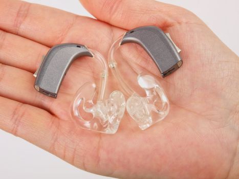 Hand holding hearing aid