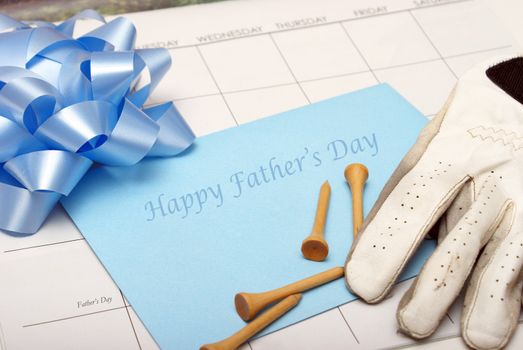 A card for father lays on a calendar with other accesories for the celebration.