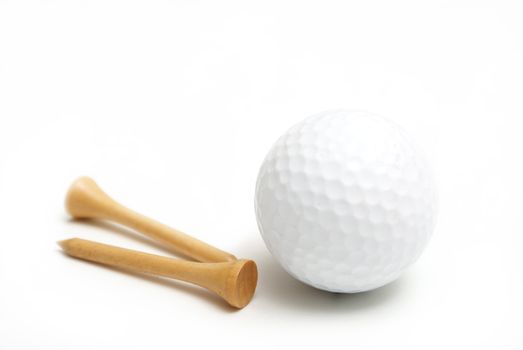 A golf ball and wooden tees are isolated over white.