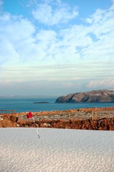 snow covering on a golf course in ireland in winter with sea and cliffs in background