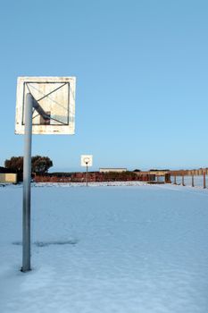 a snow covered school playground basketball court
