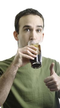 A young man drinking a tall glass of pop and giving a thumbs up, isolated against a white background