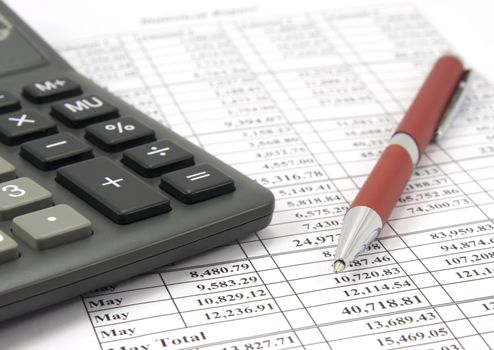 Close-up of calculator and pen on financial report