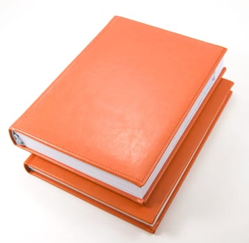 Two orange leather diaries on white background