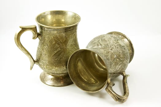 Two ancient silver tankards with shadows