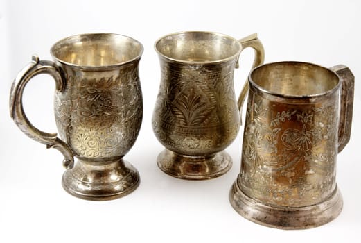 Three vintage silver beer tankards isolated over white background