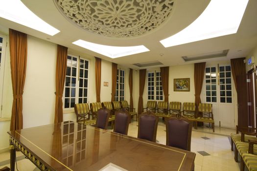 A large mahogany conference room table with leather chars
