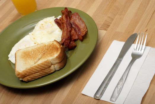 A cooked breakfast of bacon and eggs.