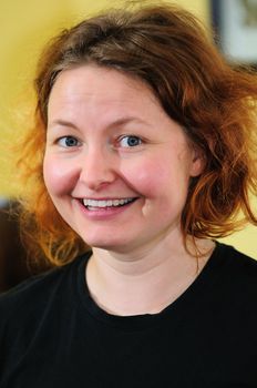 Portrait of a happy, grinning Swedish girl with red hair.