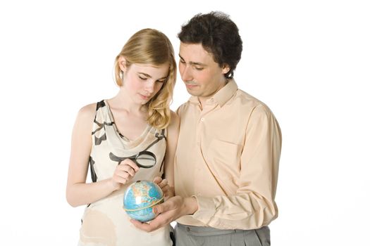 A couple looking at a small globe through a magnifier
