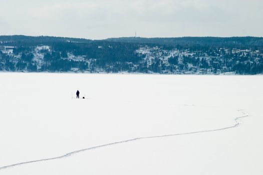 A person Ice fishing on the oslo fjord in early March.