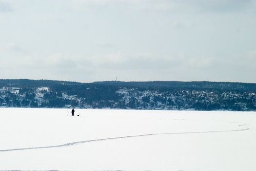 A person Ice fishing on the oslo fjord in early March.