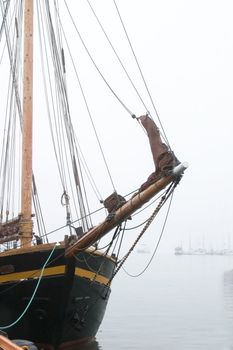An old wooden sail ship in thick fog.