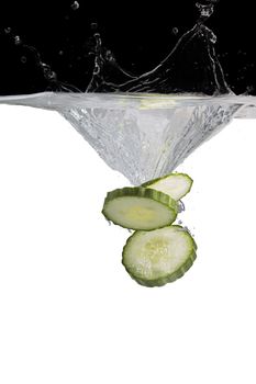 some cucumber thrown in water with black and white background