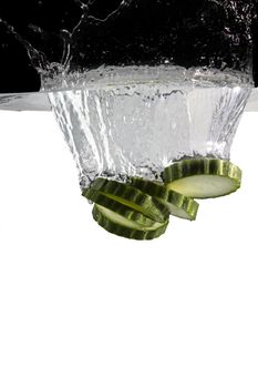 some cucumber thrown in water with black and white background