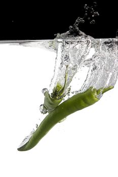 two green chilli thrown in water with black and white background