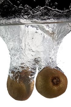 two kiwifruits thrown in water with black and white background