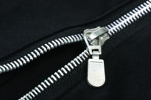 The zipper of a black trouser on a black background
