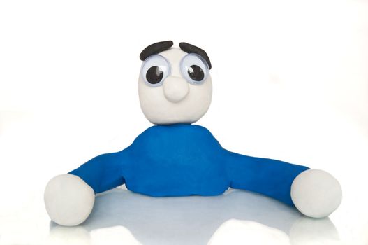 Close and low level of an isolated over white plasticine character with a blank and bewildered expression.