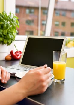 Eating breakfast at the computer in an apartment kitchen.