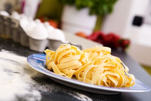 A detail of homemade fettuccine on a plate ready to be boiled