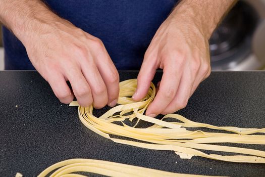 A detail of homemade fettuccine being rolled into a nest