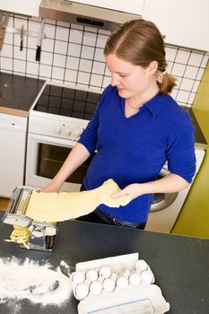 Fettuccine coming out of a manual pasta machine