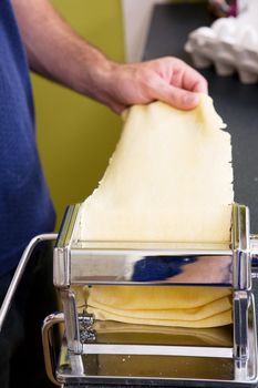 A detail shot of rolling pasta with a manual machine