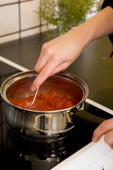 Making pizza sauce from scratch on the stove top.