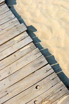 Weathered wooden boardwalk on sand dune at Couronian lagoon