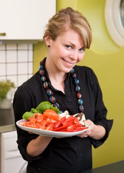 A female in the kitchen looking down on a tasty plate of vegetables